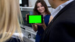 © motortion - Smiling girl showing couple plan of their new home on tablet with green screen
