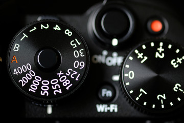 shutter speed dial of a digital camera in black background.