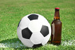 Soccer ball with beverage on green football field grass