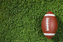Ball For American Football On Fresh Green Field Grass, Top View. Space For Text