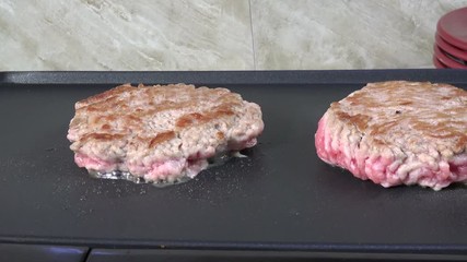 Sticker - Sausage patties simmering on a grill