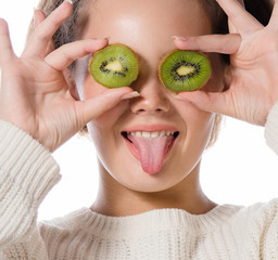 Wall Mural - portrait of attractive  caucasian smiling woman  isolated on white studio shot holding kiwi exotic fruit