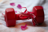 Fototapeta Tęcza - Gift-wrapped dumbbell with rose petals