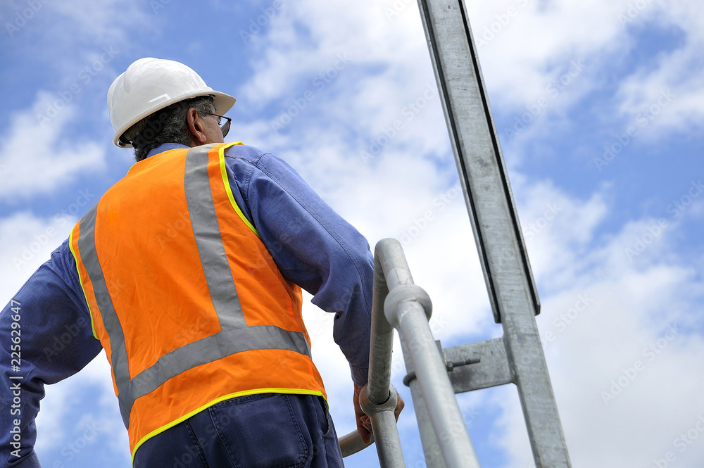Construction foreman and worker overlooks site wearing hard hat and ...