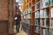 © Wavebreak Media - College student with books walking in library