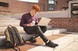 © Wavebreak Media - College student using laptop on stairs
