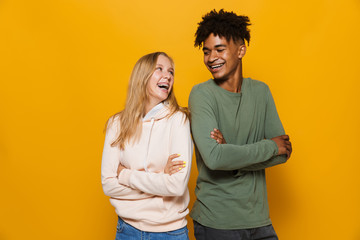 photo of teenage people man and woman 16-18 with dental braces smiling, isolated over yellow backgro