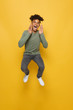 © Drobot Dean - Full length photo of satisfied african guy having stylish afro hairdo screaming or calling, isolated over yellow background