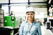 © Halfpoint - A portrait of an industrial woman engineer standing in a factory.