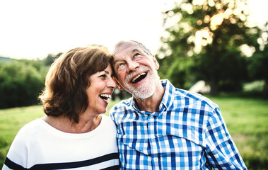 Wall Mural - A laughing senior couple in love outdoors in nature.