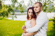 © nataliakabliuk - Bride and groom in a park kissing. Young wedding couple newlyweds bride and groom at a wedding in nature green park near lake. Walking and kissing photo portrait. Before wedding ceremony.