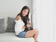 © chayathon2000 - Asian woman playing with little dog black color in living room lifestyle girl with pet