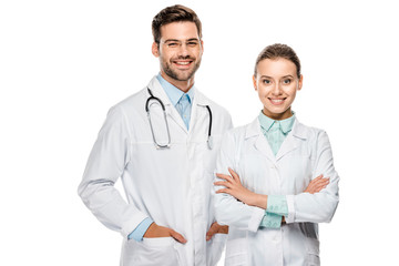 Wall Mural - handsome happy male doctor standing near female colleague with crossed arms isolated on white