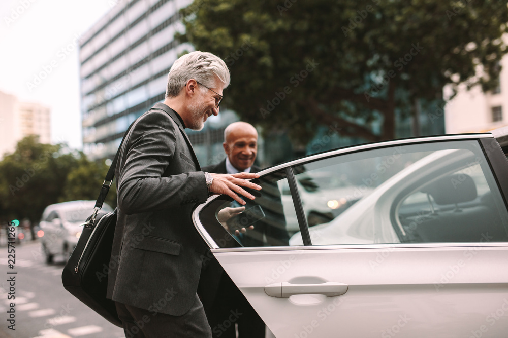 Happy businessman getting into a cab