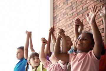 Little children holding hands together indoors. Unity concept