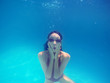 Beautiful young woman swimming in pool, underwater view