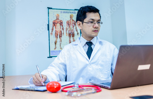 Fotografie, Obraz Doctor and his table in the office with stethoscope, miniature heart, laptop and smart phone