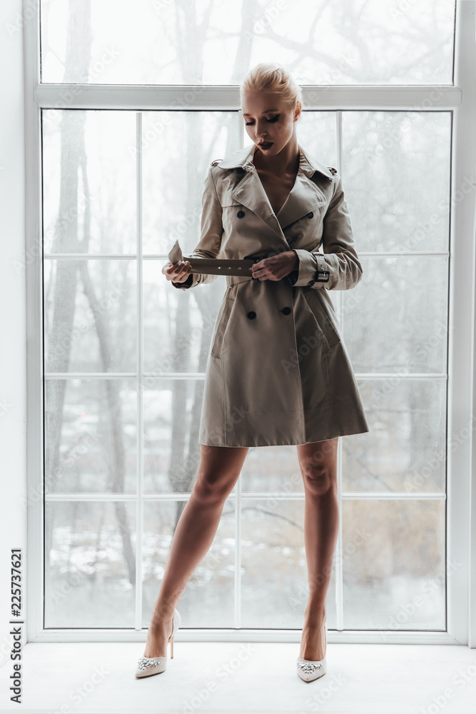 Model on the background of the window, fashion model in lingerie and trench  coat Stock Photo | Adobe Stock