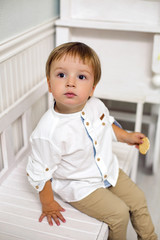 portrait of a child boy two years old sitting on a wooden bench