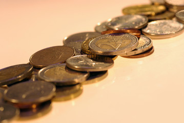 photo of metal coins of different currencies on white background