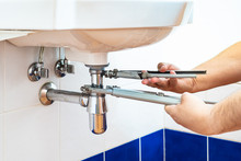 Plumber Unscrews Sink Siphon By Two Pipe-wrenches