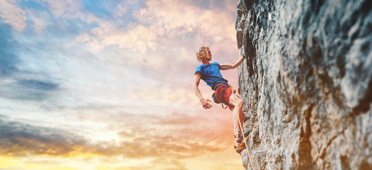 Wall Mural - male rock climber resting while climbing the challenging route on the rocky wall