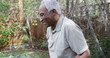 © Mark Adams - Happy senior black man gardening in yard