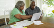 © Mark Adams - Senior black couple looking at laptop computer