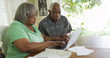 © Mark Adams - Elderly black woman typing on laptop with husband