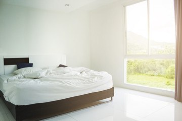 Wall Mural - White Pillow, White Blanket And White Towel On Bed In Bedroom With Soft Lighting In Morning.