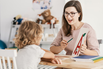 Wall Mural - A young child development therapist  working with a child to overcome his problems