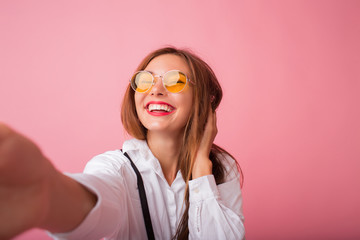 Wall Mural - Self portrait of nice, amazing, pretty, positive, sexy woman shooting selfie in two hands on front camera, blowing air kiss to her boyfriend.Self portrait of comic crazy girl in casual outfit shooting