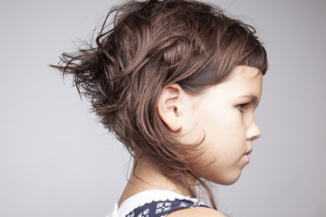 Little angry girl with stylish haircut, profile face