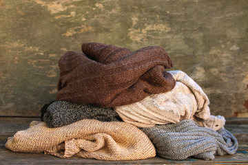 Pile of colorful warm clothes on wooden background.