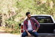 © LIGHTFIELD STUDIOS - confident bearded man sitting on pickup truck in forest