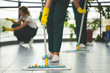 © Photographee.eu - Close-up on cleaning specialist with yellow gloves holding mop while wiping floor