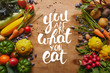 © LIGHTFIELD STUDIOS - Frame of healthy food vegetables and beans on wooden table with 'you are what you eat' lettering