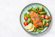Baked salmon fish fillet with fresh salad top view.