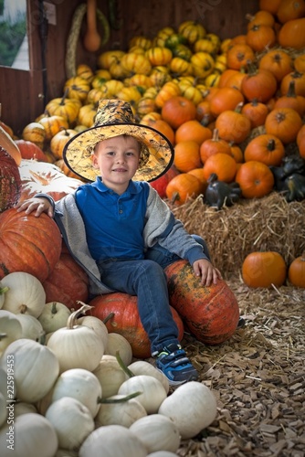 Fotografía Little cute boy in halloween costume with pumpkins decoration on background