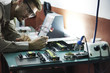 © PhotoAlto - Engineer soldering circuit board in office