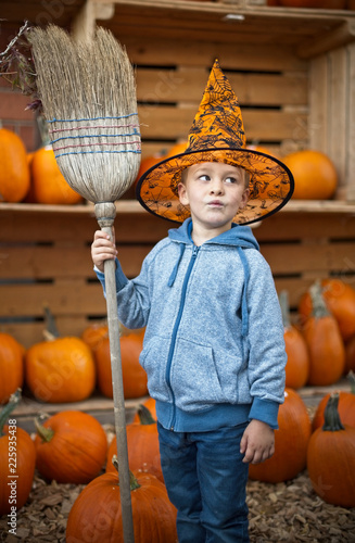 Fotografía Little cute boy in halloween costume with pumpkins decoration on background