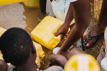 Wall Mural - People getting water at a well in Uganda, Africa