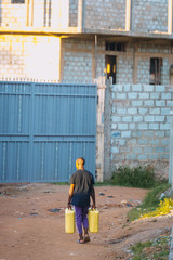 Wall Mural - Man carrying water cans in Uganda, Africa