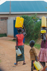 Wall Mural - woman carrying water can in Uganda, Africa