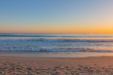 Sunset Over Ocean Waves And Beach