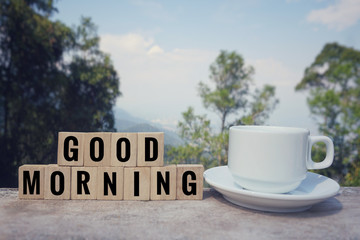 Motivational and inspirational quote - ‘GOOD MORNING’ written on wooden blocks. Blurred styled background.