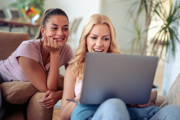 Sticker - Two happy female friends using laptop