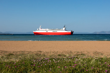 Red ferryboat and beach in Rafina, Greece.