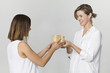 © lukas_zb - Young woman gives a gift to her friend. Smiling two women scene against white background