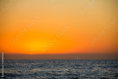Fotografie, Obraz Sunrise on "Las Rotas" beach in Denia, Spain, Ibiza in the background